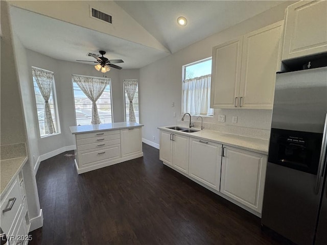 kitchen with stainless steel fridge with ice dispenser, vaulted ceiling, white cabinets, dark wood-type flooring, and ceiling fan