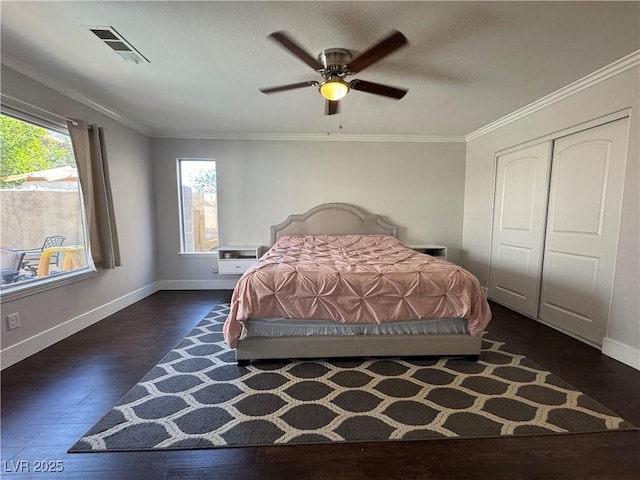 bedroom with baseboards, visible vents, multiple windows, and wood finished floors