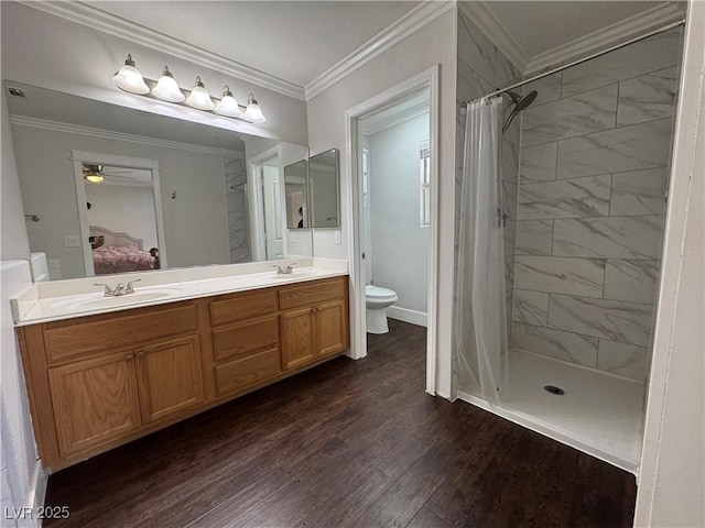 bathroom featuring a sink, a tile shower, toilet, and ensuite bath