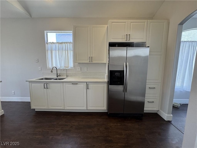 kitchen featuring stainless steel fridge with ice dispenser, white cabinetry, and healthy amount of natural light