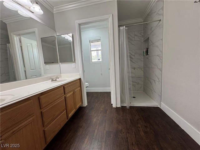 bathroom featuring double vanity, wood finished floors, baseboards, toilet, and tiled shower