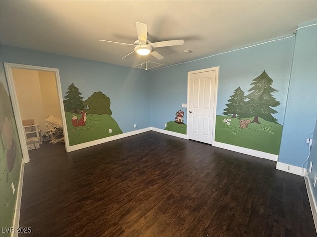 spare room with wood finished floors and a ceiling fan