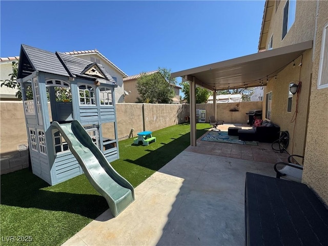 fenced backyard featuring a playground and a patio