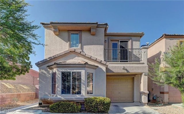 traditional home featuring a garage, stucco siding, concrete driveway, and a balcony