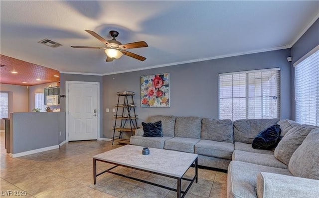 living room featuring light tile patterned floors, ceiling fan, ornamental molding, and visible vents