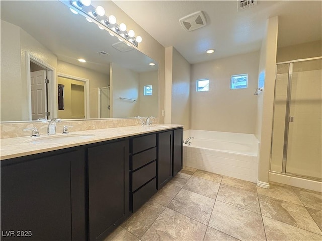 bathroom featuring double vanity, a shower stall, a sink, and a garden tub