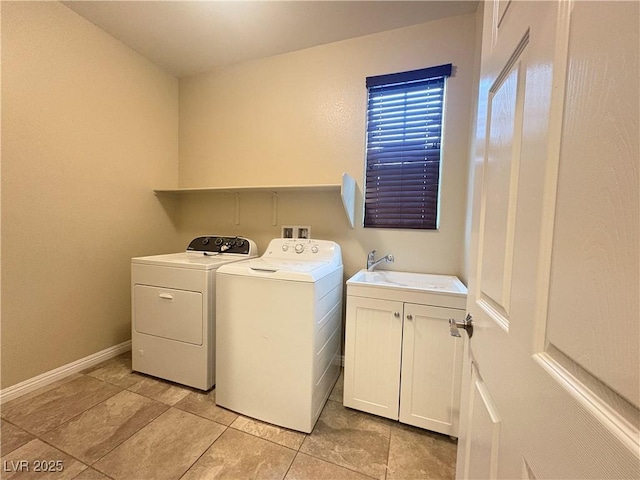laundry area with washing machine and clothes dryer, cabinet space, a sink, baseboards, and light tile patterned floors