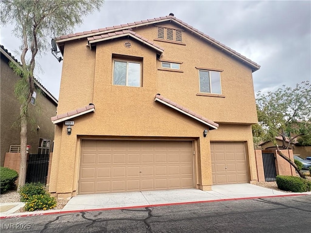 view of front of house featuring stucco siding, driveway, a tile roof, and a garage