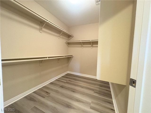 spacious closet featuring visible vents and wood finished floors