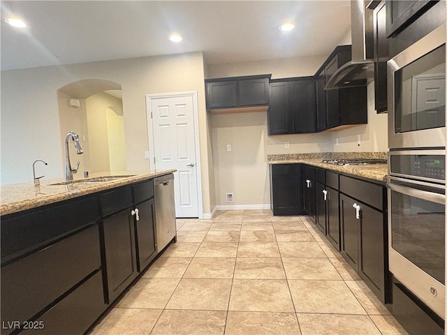 kitchen with a sink, arched walkways, light tile patterned floors, and light stone countertops