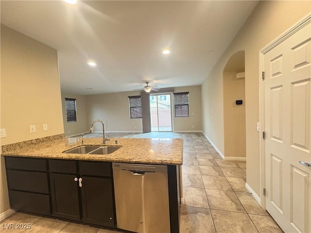 kitchen with a peninsula, light stone countertops, ceiling fan, a sink, and dishwasher
