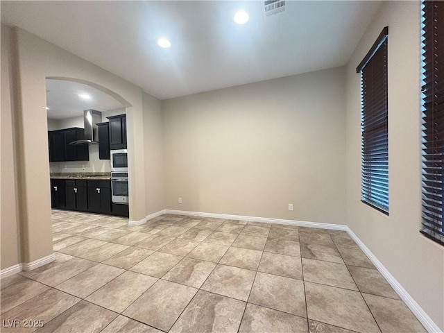interior space featuring visible vents, baseboards, recessed lighting, arched walkways, and light tile patterned floors
