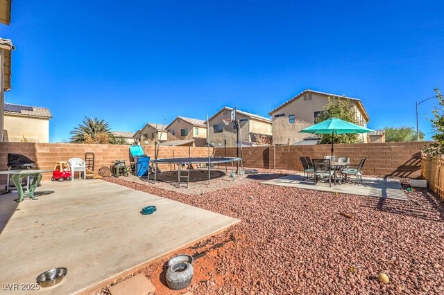 3592 Gloucester Gate St, Las Vegas, NV 89122 - view of yard with a patio, a fenced backyard, and a trampoline