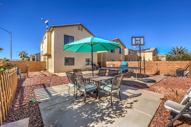 3592 Gloucester Gate St, Las Vegas, NV 89122 - view of patio featuring outdoor dining space, a fenced backyard, and a trampoline