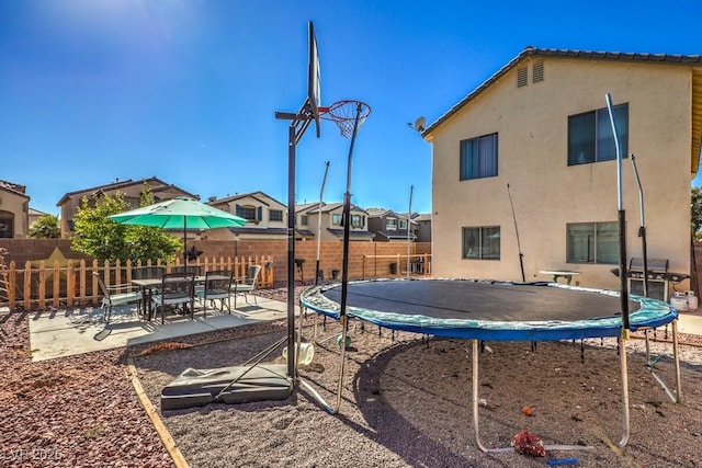 3592 Gloucester Gate St, Las Vegas, NV 89122 - exterior space with a patio, a fenced backyard, stucco siding, a trampoline, and a residential view