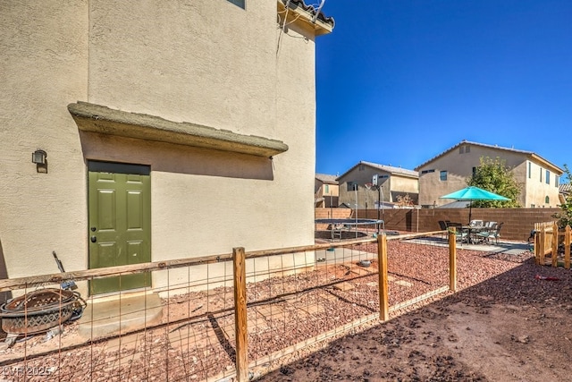 3592 Gloucester Gate St, Las Vegas, NV 89122 - view of yard featuring a patio, a fenced backyard, and a trampoline