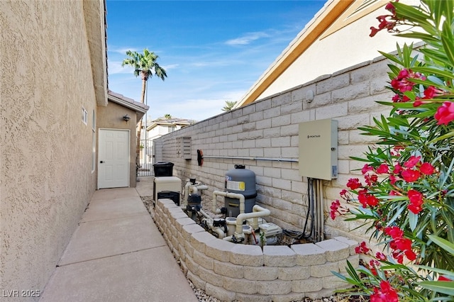 view of side of home featuring fence and stucco siding