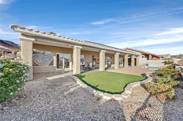 rear view of property with a patio area, stucco siding, and fence