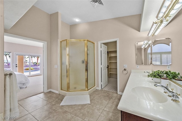 ensuite bathroom featuring connected bathroom, tile patterned floors, visible vents, and a sink
