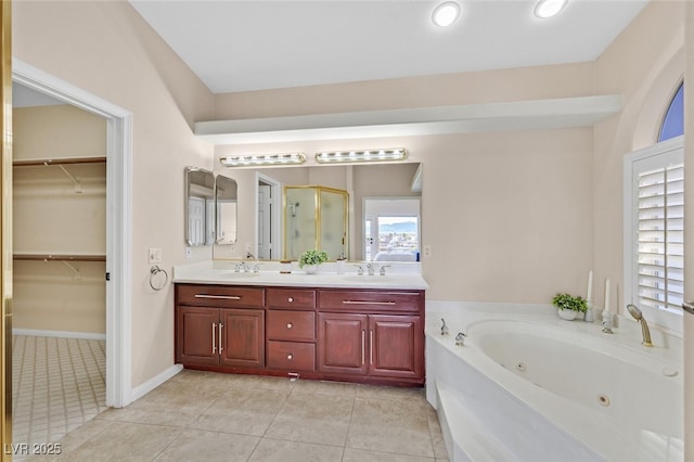 bathroom with double vanity, tile patterned floors, a shower stall, and a sink
