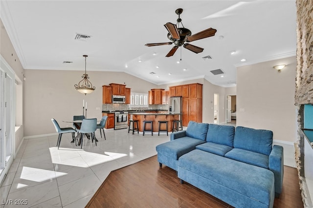 living area featuring crown molding, a ceiling fan, visible vents, and lofted ceiling