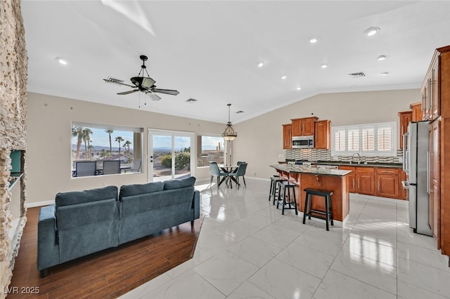 living room with ornamental molding, a ceiling fan, lofted ceiling, and visible vents