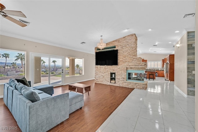 living area featuring visible vents, plenty of natural light, and ornamental molding
