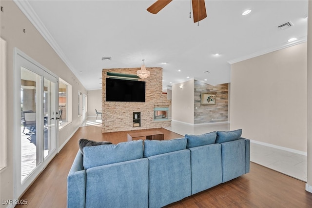 living area featuring ceiling fan, baseboards, wood finished floors, vaulted ceiling, and visible vents