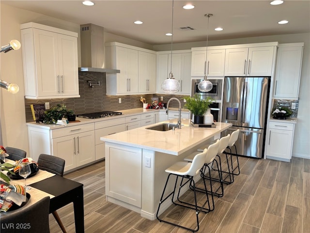 929 Hunter Shores Ave, North Las Vegas, NV 89084 - kitchen with stainless steel appliances, a sink, wall chimney exhaust hood, white cabinets, and light wood-style flooring