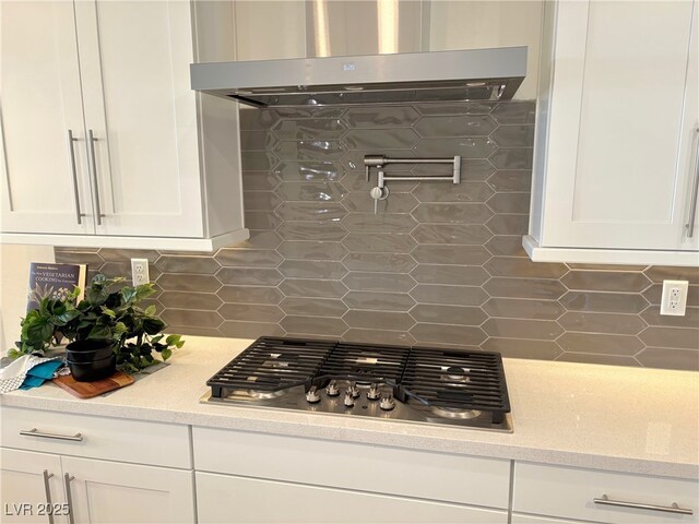 929 Hunter Shores Ave, North Las Vegas, NV 89084 - kitchen featuring range hood, decorative backsplash, stainless steel gas cooktop, white cabinetry, and light stone countertops