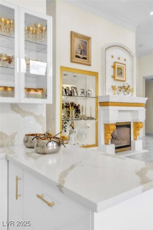 bar with crown molding and a large fireplace