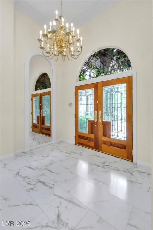 foyer featuring baseboards, french doors, marble finish floor, and a chandelier