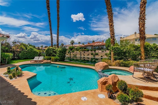 view of pool featuring a patio, fence, and a pool with connected hot tub