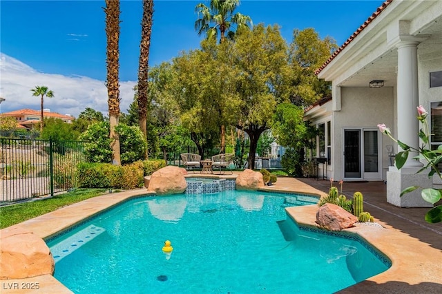 view of pool featuring fence, a patio, and a pool with connected hot tub