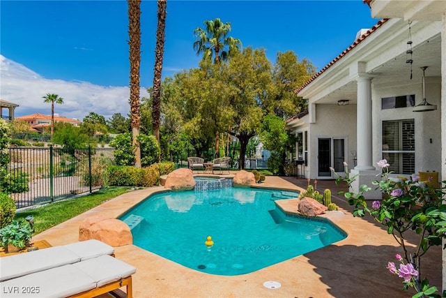 view of swimming pool featuring fence, a pool with connected hot tub, and a patio area