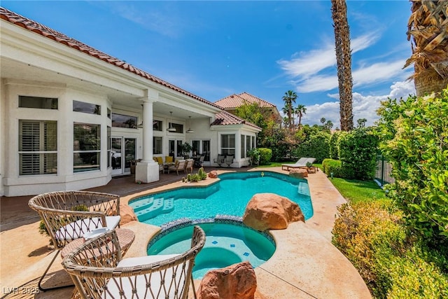 view of pool featuring a patio area, a pool with connected hot tub, and fence