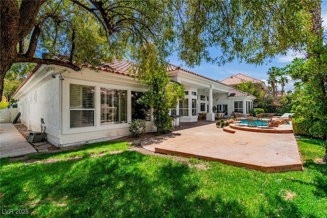 back of house featuring a patio, an outdoor pool, a yard, and a tile roof