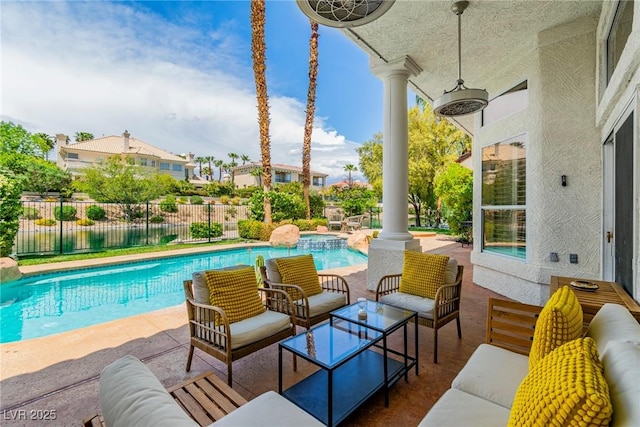 view of pool featuring fence, a patio, a pool with connected hot tub, and outdoor lounge area