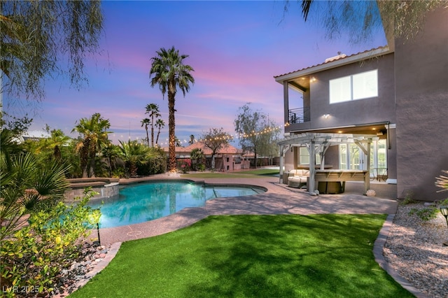 view of pool featuring a pool with connected hot tub, a patio, and a yard