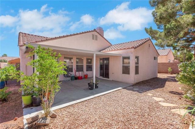 5900 Red Umber Ave, Las Vegas, NV 89130 - back of property with a tiled roof, stucco siding, a chimney, and a patio area