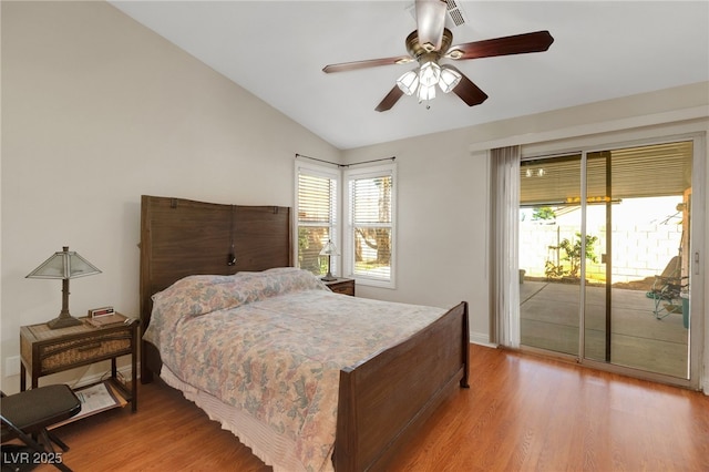 bedroom featuring access to outside, light wood-style floors, vaulted ceiling, and multiple windows