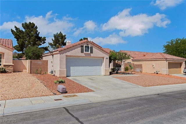 mediterranean / spanish home featuring driveway, a garage, fence, stucco siding, and a tiled roof