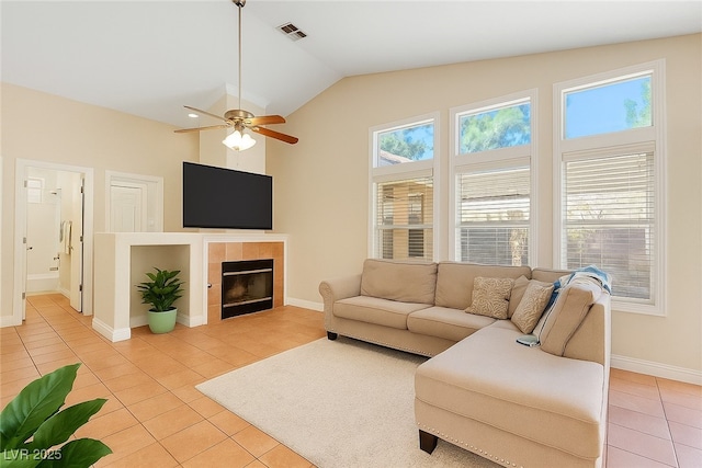 5900 Red Umber Ave, Las Vegas, NV 89130 - living area featuring light tile patterned floors, lofted ceiling, a tiled fireplace, and a ceiling fan