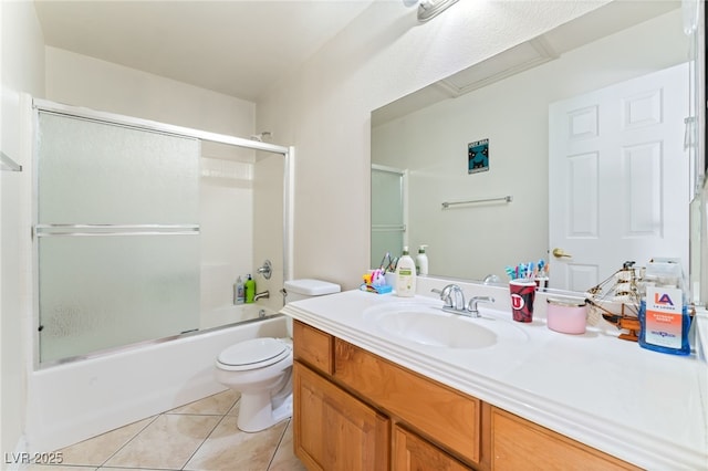 bathroom with vanity, tile patterned flooring, combined bath / shower with glass door, and toilet
