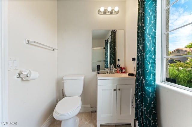full bath featuring vanity, baseboards, tile patterned floors, and toilet