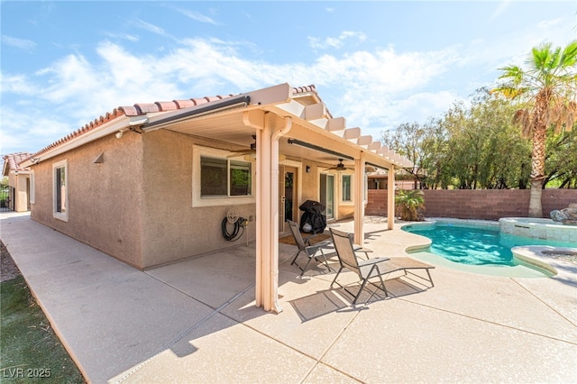 view of pool with a pool with connected hot tub, a ceiling fan, a fenced backyard, and a patio area
