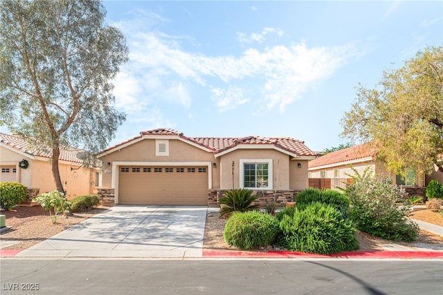 mediterranean / spanish-style home featuring an attached garage, stone siding, stucco siding, a tiled roof, and driveway