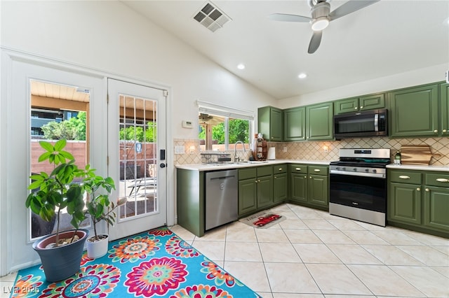 kitchen featuring backsplash, green cabinetry, appliances with stainless steel finishes, and visible vents
