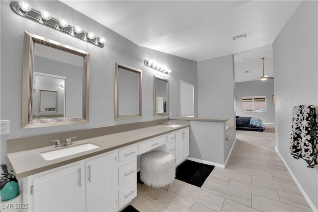 full bath with a sink, connected bathroom, double vanity, and visible vents