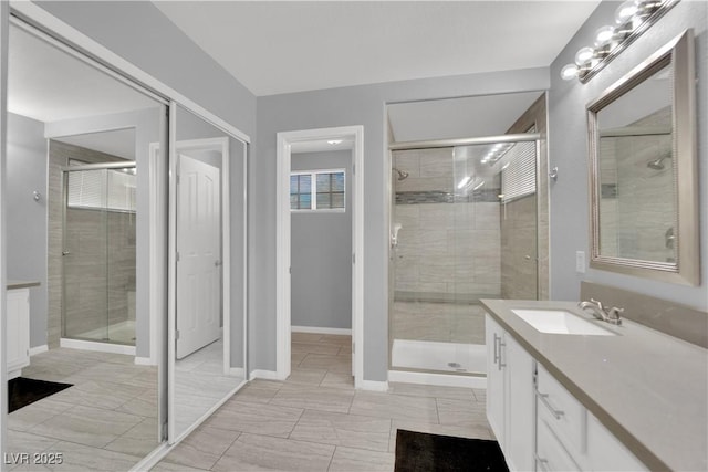 bathroom with vanity, baseboards, and a stall shower